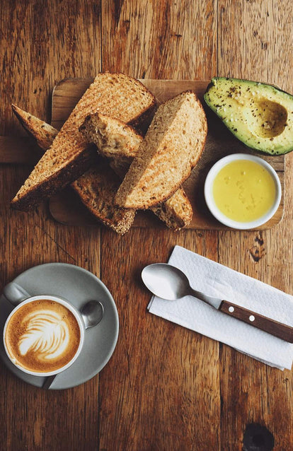 An espresso shot from above with toast cut and arranged carefully on a chopping board next to it.