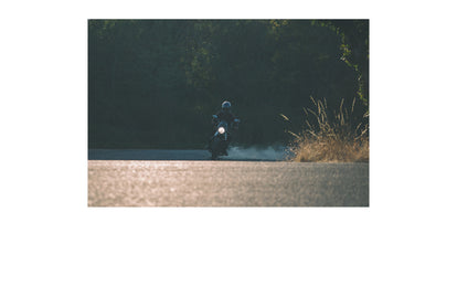 A low to the ground shot of a motorcycle speeding around a corner.