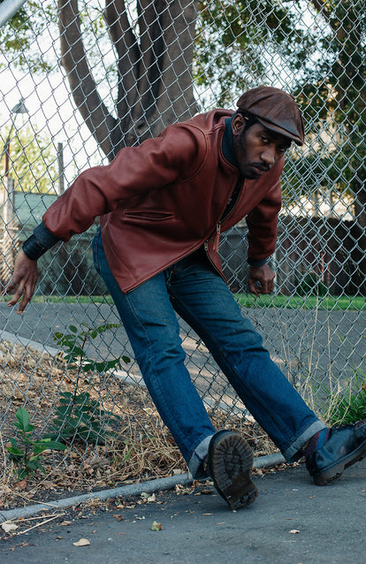 Modelling The Presido Jacket, leaning against a chainlink fence.