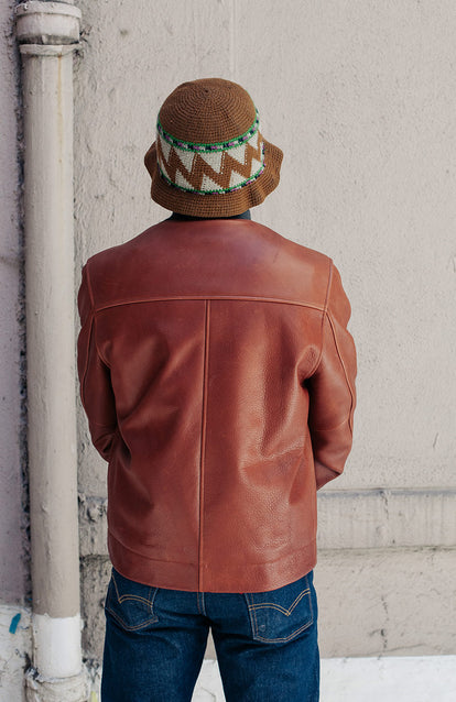 Rear view of a man wearing a brown leather jacket.