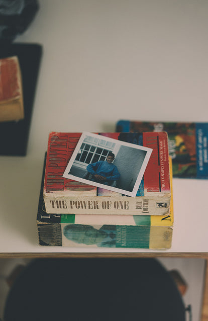 Polaroid of an African teen, on top of two novels about Nelson Mandela.