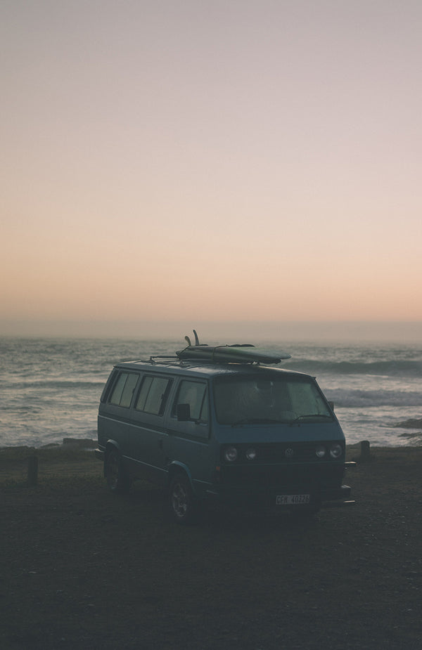 Campervan parked up in a misty oceanside spot.