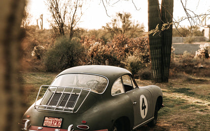 A vintage Porsche with luggage rack and racing decals.