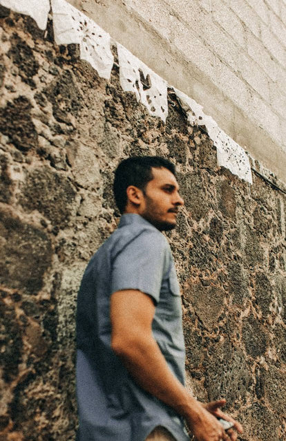 our guy rocking the officer shirt next to a wall