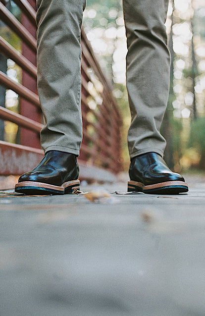 A close up of a man wearing a pair of boots in the Texas Fall.