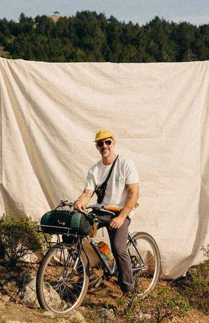 Our guy sitting on a bike in The Organic Cotton Tee in Trail Buddies