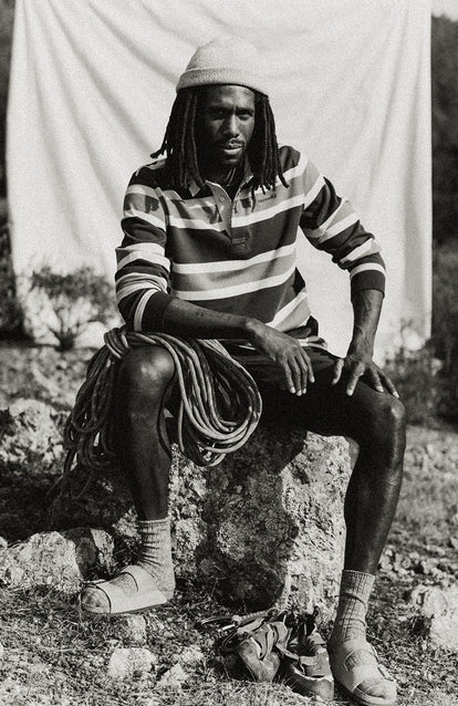 Our guy wearing The Rugby Shirt in Navy Stripe, sitting with climbing robe