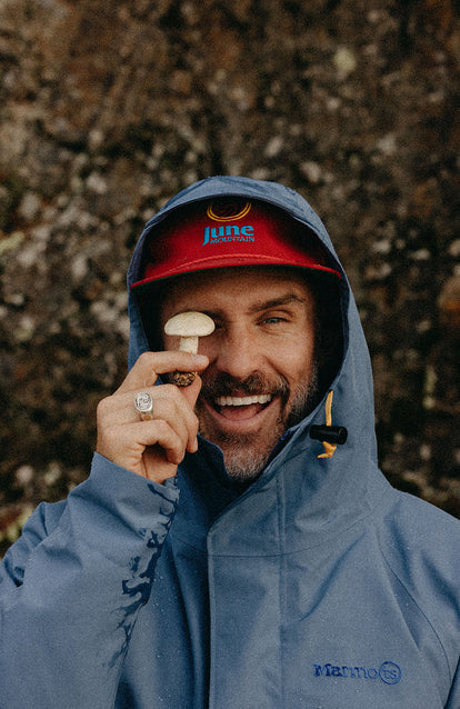 Our guy holding a mushroom to his eye, wearing The Owens Parka