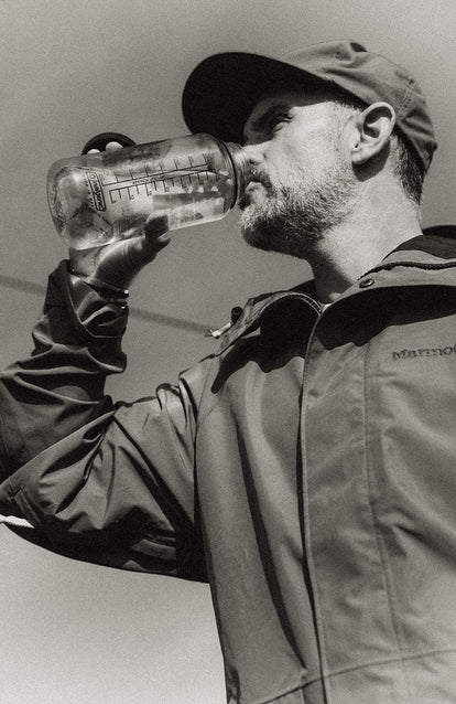 Our guy drinking water, wearing The Owens Parka