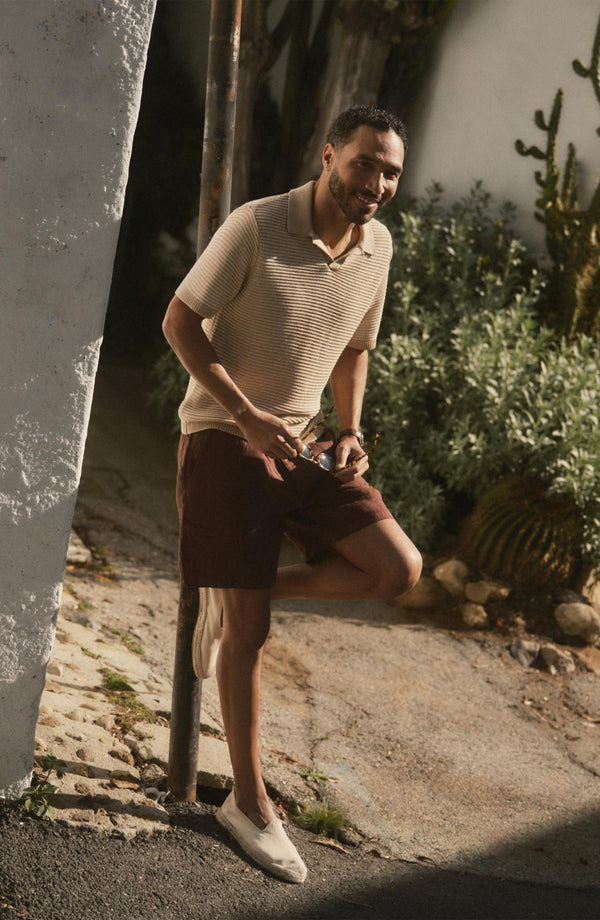 fit model leaning against a pole wearing The Apres Short in Burgundy Hemp