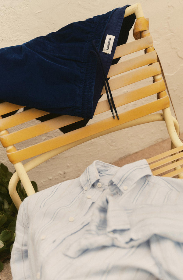 editorial flatlay of The Apres Short in Rinsed Indigo Pincord on a chair