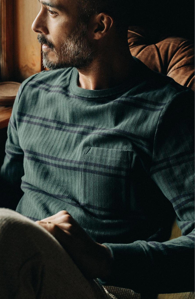 fit model sitting wearing The Colton Crew in Dark Forest Stripe
