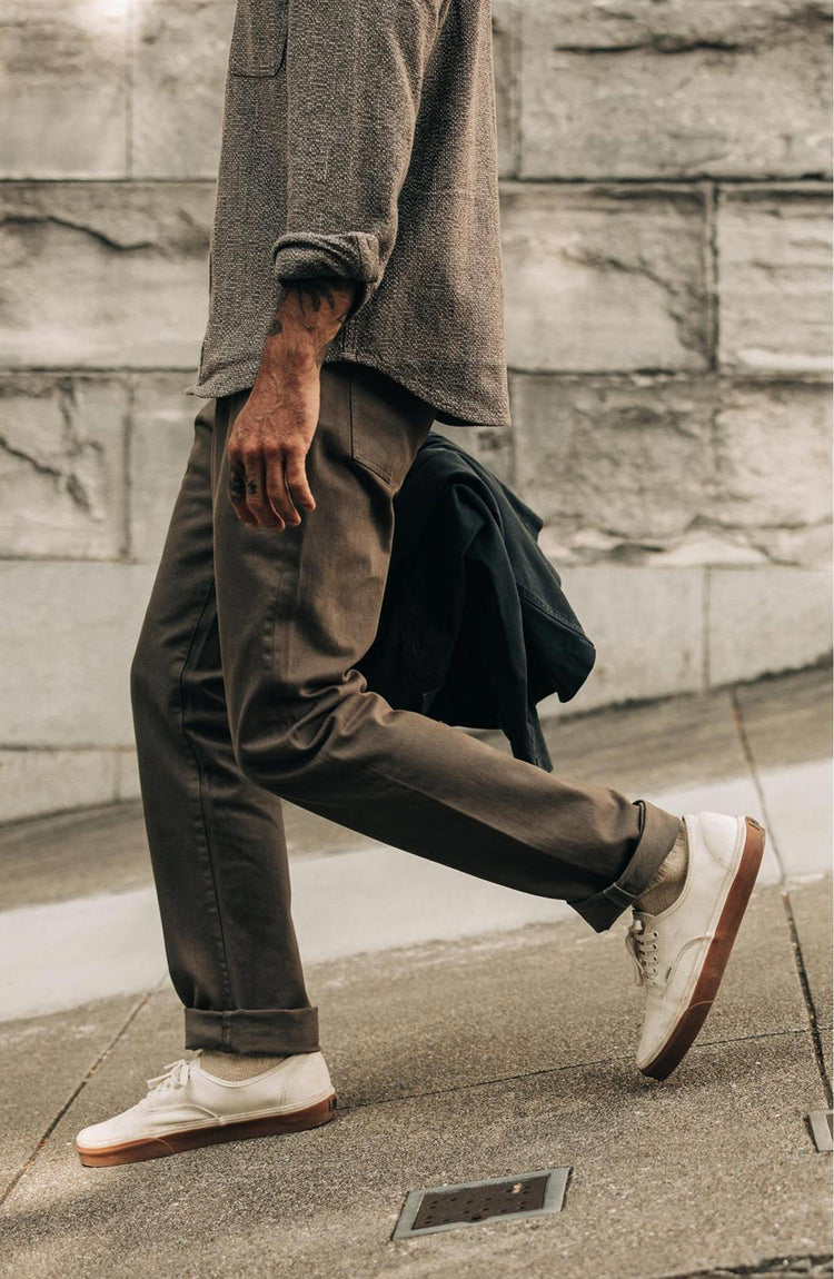 fit model walking down a hill in The Democratic All Day Pant in Fatigue Olive Selvage Denim