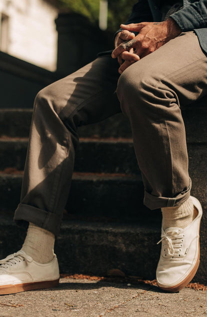 fit model sitting wearing The Democratic All Day Pant in Fatigue Olive Selvage Denim