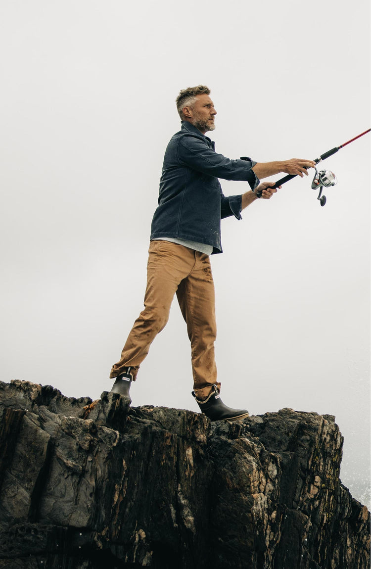 fit model fishing wearing The Democratic All Day Pant in Tobacco Selvage Denim