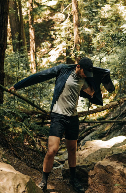 fit model putting on The Deploy Packable Shell in Dark Navy