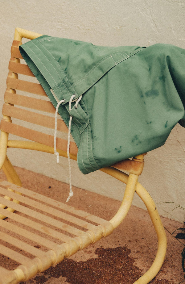 editorial flatlay of The Drift Boardshort in Ivy in the pool