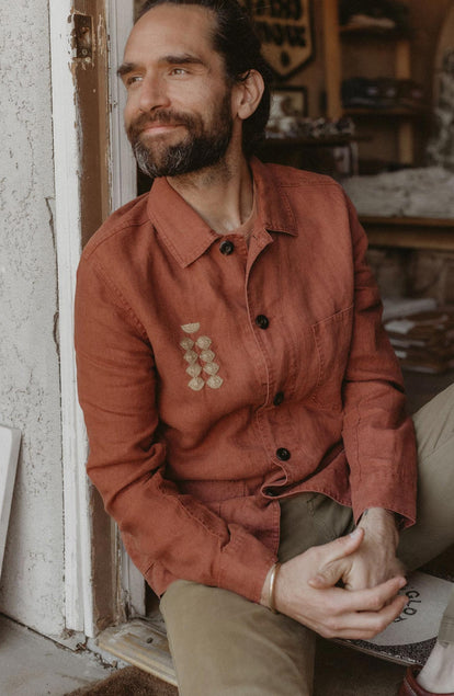 Daren sitting by the doorway in The Embroidered Ojai in Dried Guajillo Hemp