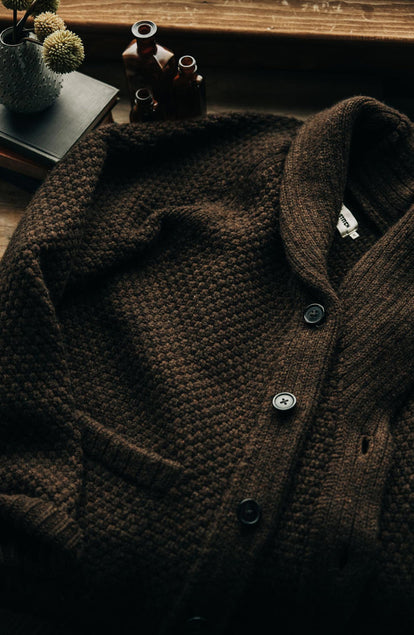 The Fisherman Shawl Cardigan on a table