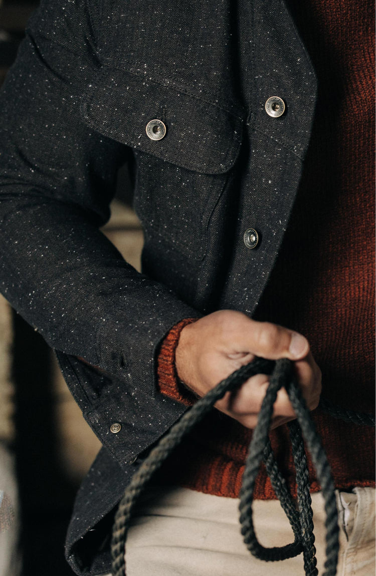 fit model holding a rope posing in The Long Haul Jacket in Peat Nep Herringbone