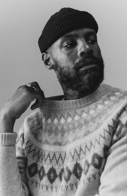 fit model holding the collar of The Magnus Sweater in Natural