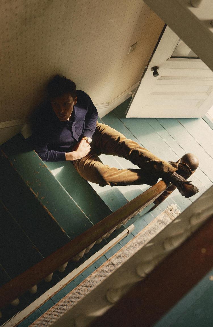 fit model sitting on stairs wearing The Nichols Polo in Nocturne Cotton Cashmere