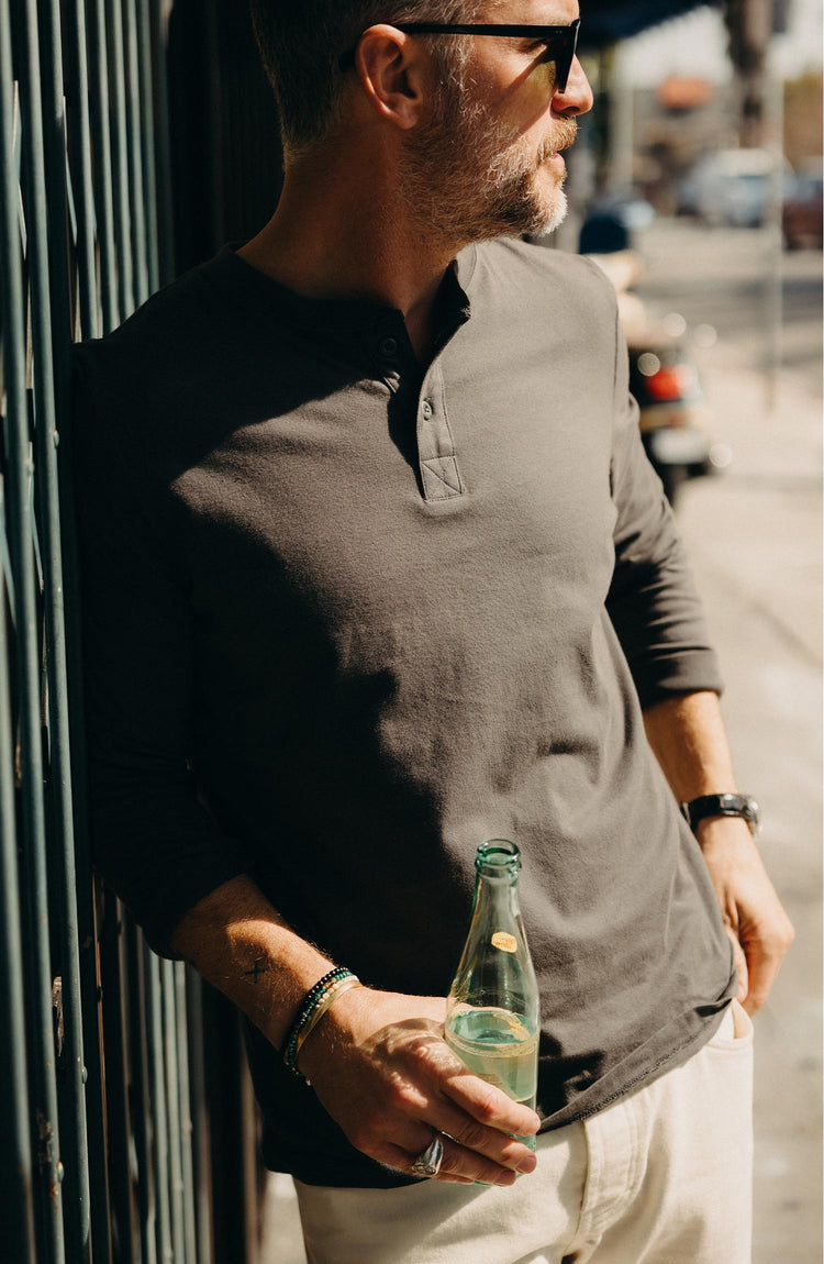 fit model with his arms crossed wearing The Organic Cotton Henley in Faded Black
