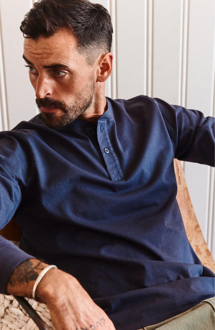fit model sitting wearing The Organic Cotton Henley in Navy