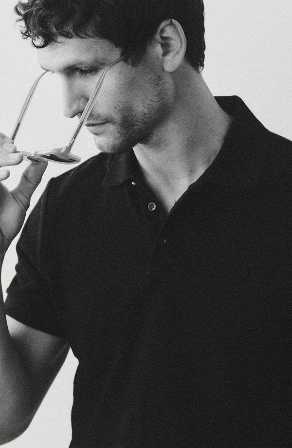fit model putting his glasses on wearing The Pacific Polo in Rinsed Indigo Pique