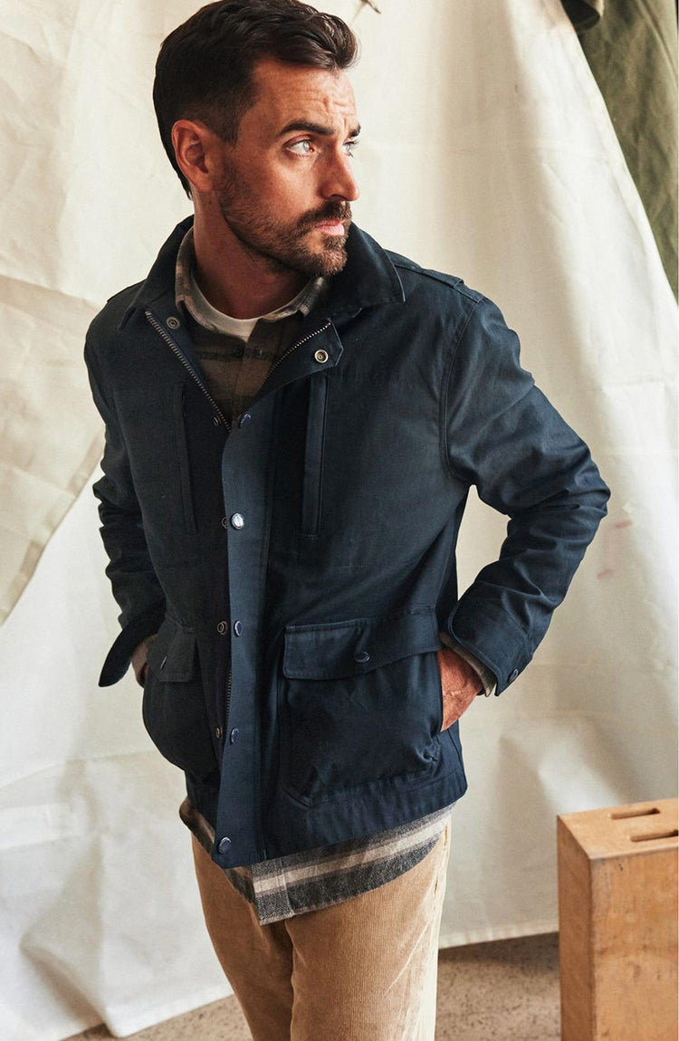 fit model with his hands in his pockets wearing The Pathfinder Jacket in Dark Navy Dry Wax
