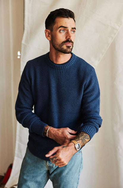 fit model adjusting sleeves on The Russell Sweater in Heather Blue