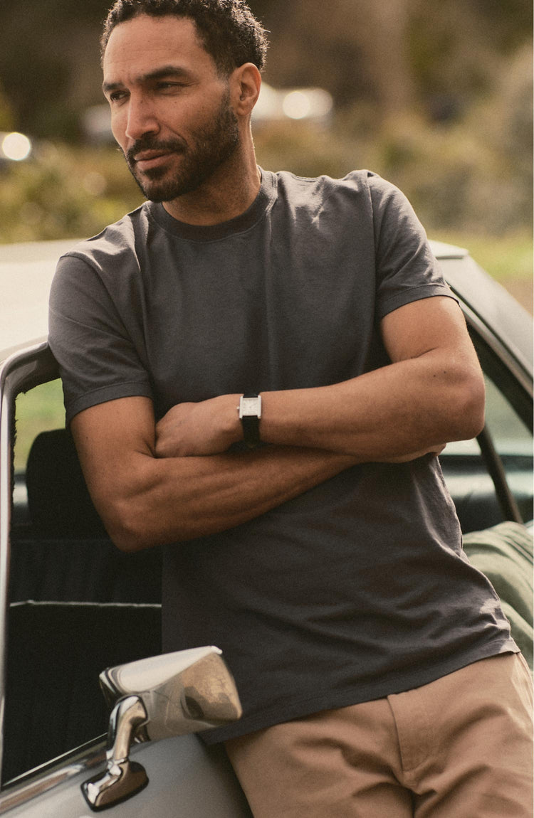 fit model leaning against a car wearing The Cotton Hemp Tee in Charcoal