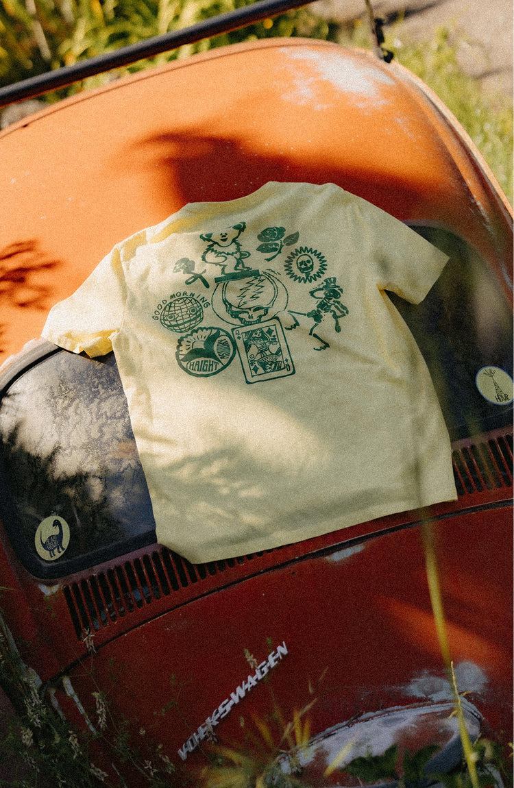 editorial flatlay of The Organic Cotton Tee in Lemon Stamp on a car