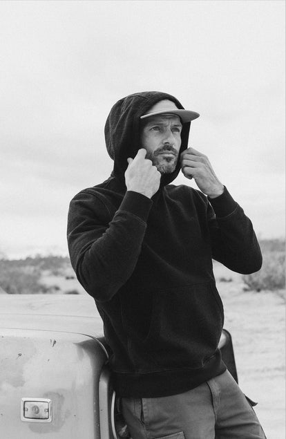 editorial image of The Apres Hoodie in Black Indigo Terry hanging