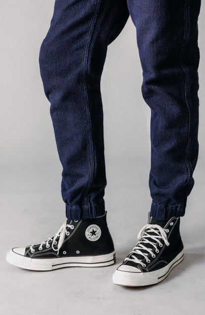 editorial flatlay of The Apres Pant in Rinsed Indigo Sashiko next to other apres pant