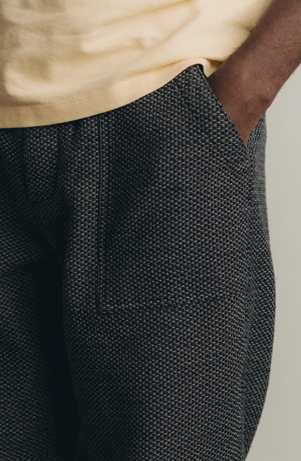 fit model with his hand in his pocket wearing The Breakwater Pant in Charcoal Sashiko
