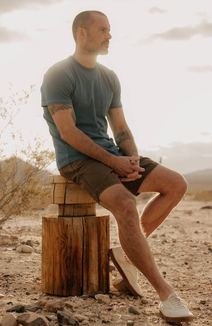 fit model sitting wearing The Camp Short in Aged Penny Chipped Canvas