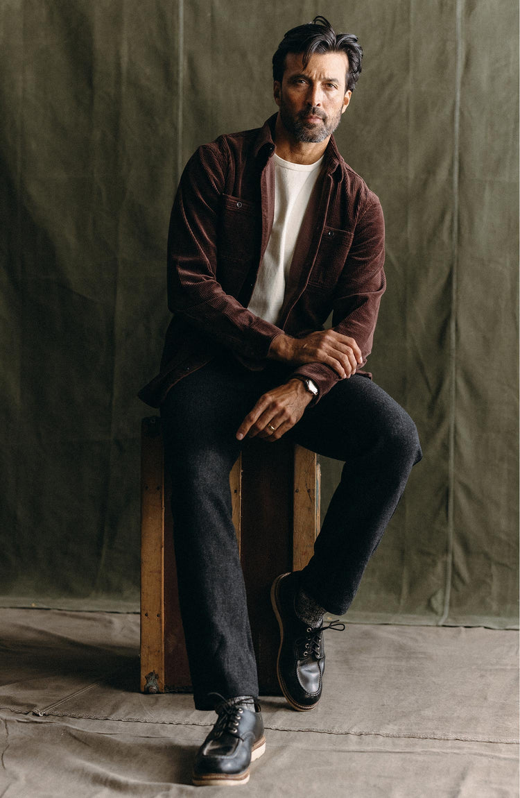 fit model leaning on a chair wearing The Carnegie Pant in Heather Charcoal Wool