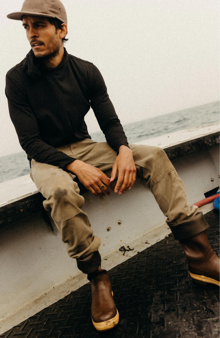 fit model leaning against the wall wearing The Chore Pant in Stone Chipped Canvas
