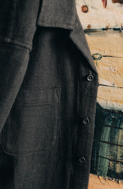 editorial image of The Conrad Shirt in Faded Black Linen hanging on a painting