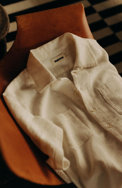editorial flatlay of The Conrad Shirt in Vintage White Linen on a chair
