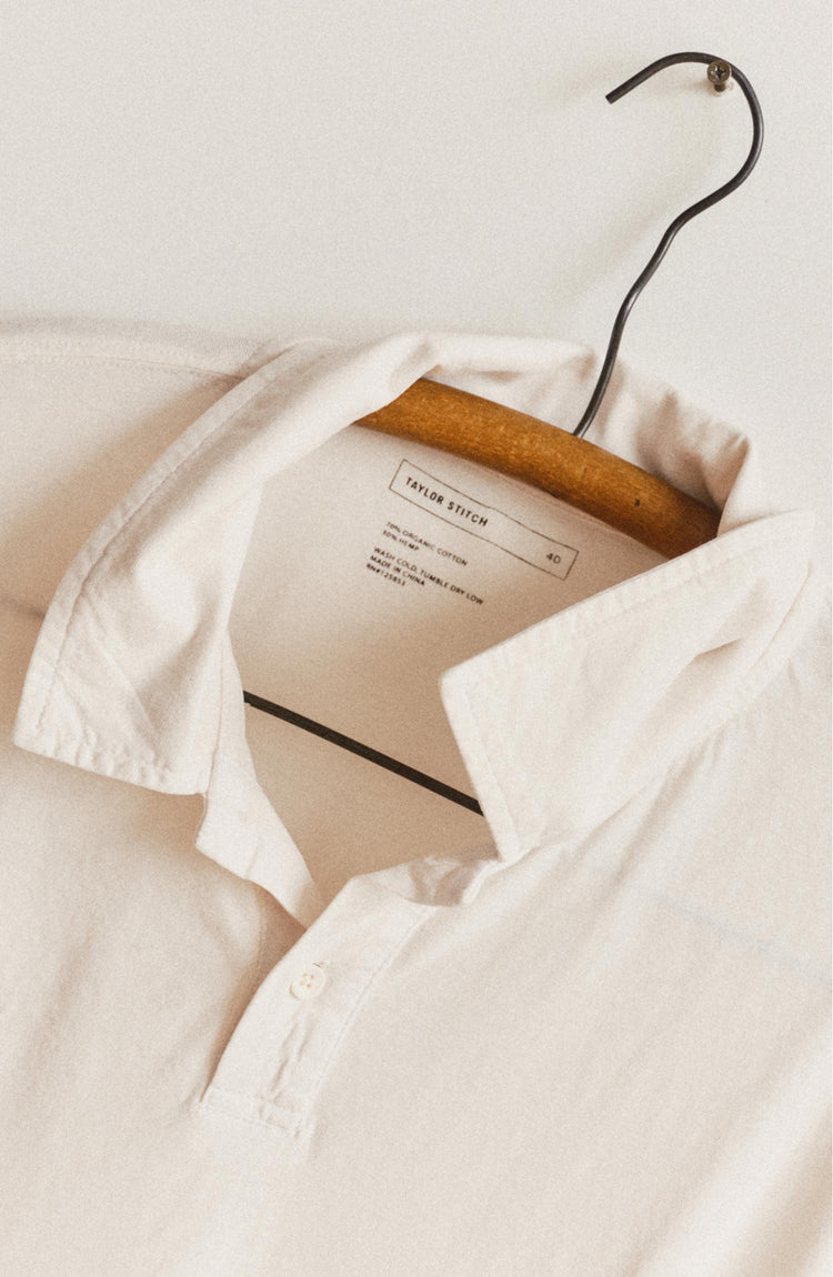 editorial image of The Cotton Hemp Polo in Vintage White on a hanger