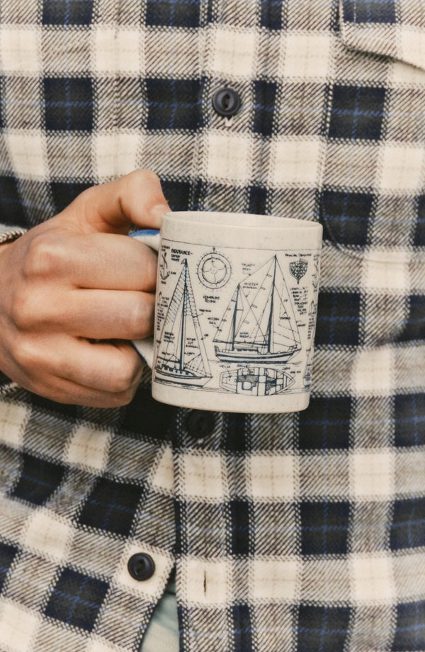 fit model holding a mug wearing The Crater Shirt in Woodland Plaid