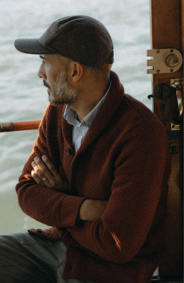 fit model sitting wearing The Crawford Sweater in Rust