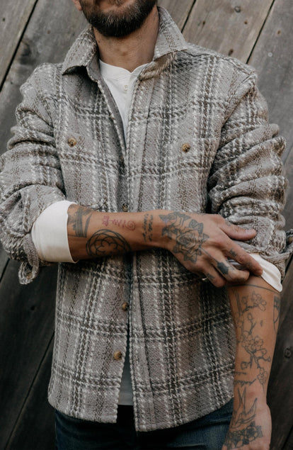fit model adjusting the sleeves on The Cutter Overshirt in Grey Plaid