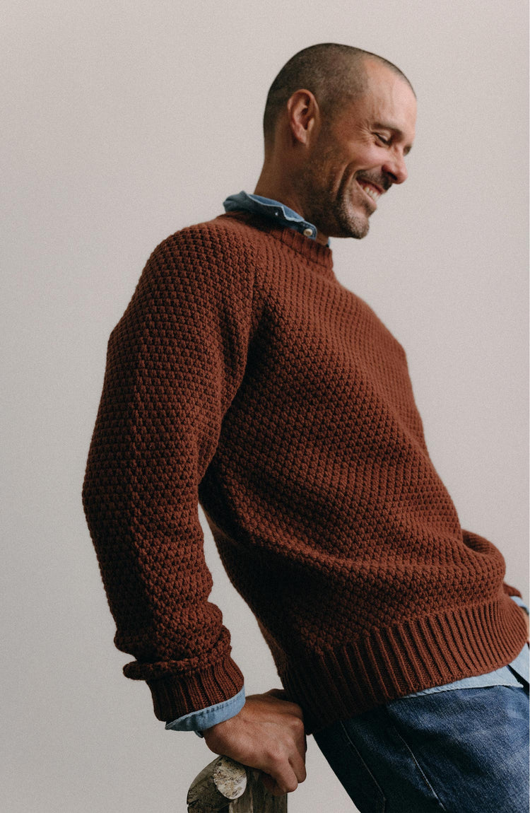 fit model posing in The Fisherman Sweater in Heather Brick Merino
