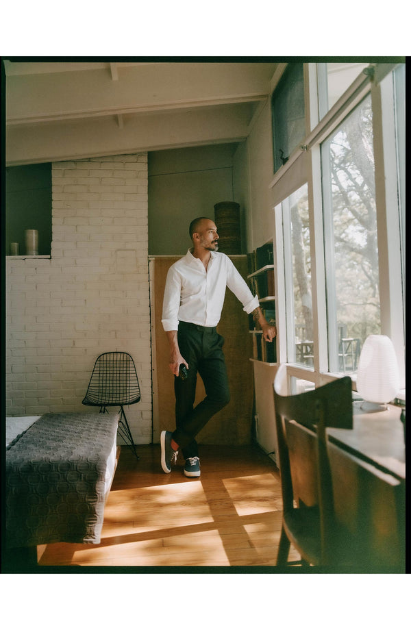 fit model leaning against a bookshelf wearing The Hyde Shirt in White Pinpoint Oxford