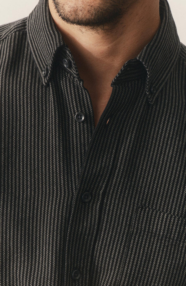 fit model leaning against the wall wearing The Jack in Roped Black Indigo