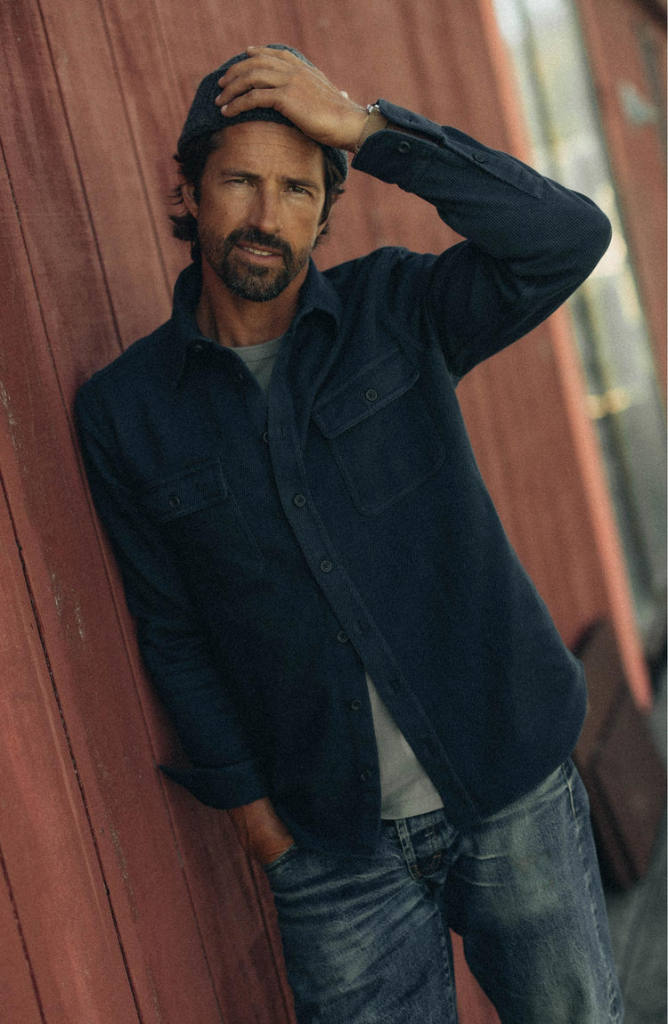 fit model leaning against the wall wearing The Ledge Shirt in Dark Navy Twill