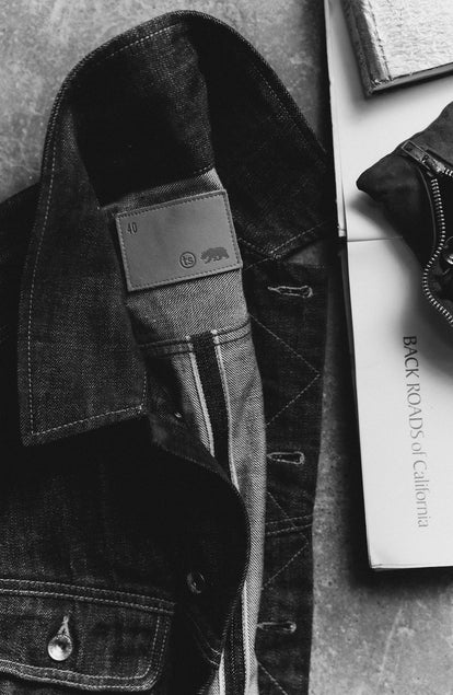 editorial image of The Long Haul Jacket in Rinsed Organic Selvedge next to a book